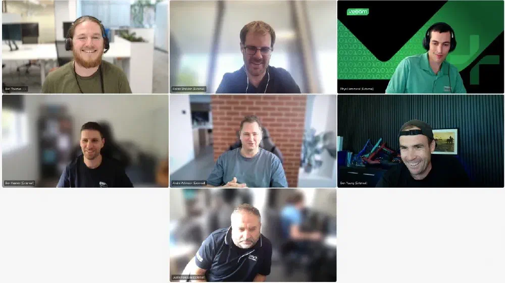 Veeam 100 ANZ team virtual meeting featuring seven participants in a video call. The team members appear engaged, with some smiling and others in discussion. The Veeam-branded background is visible in one participant’s frame, reinforcing the team’s affiliation. This image highlights collaboration among Veeam’s Australia and New Zealand (ANZ) community.