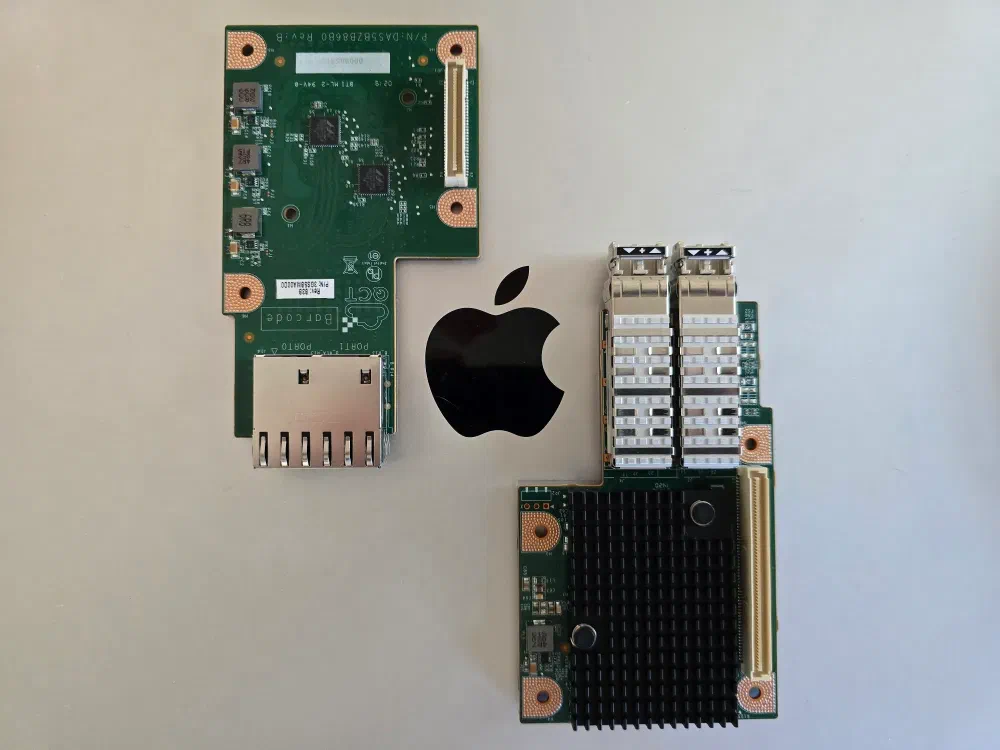 Two network cards laid out on a Macbook lid, framing the apple logo on the silver background.
